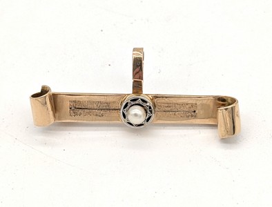BROCHE en or (750) centrée d'une perle, évoquant...